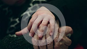 Hand of a little girl fondling old Â hands of grandmother with love.